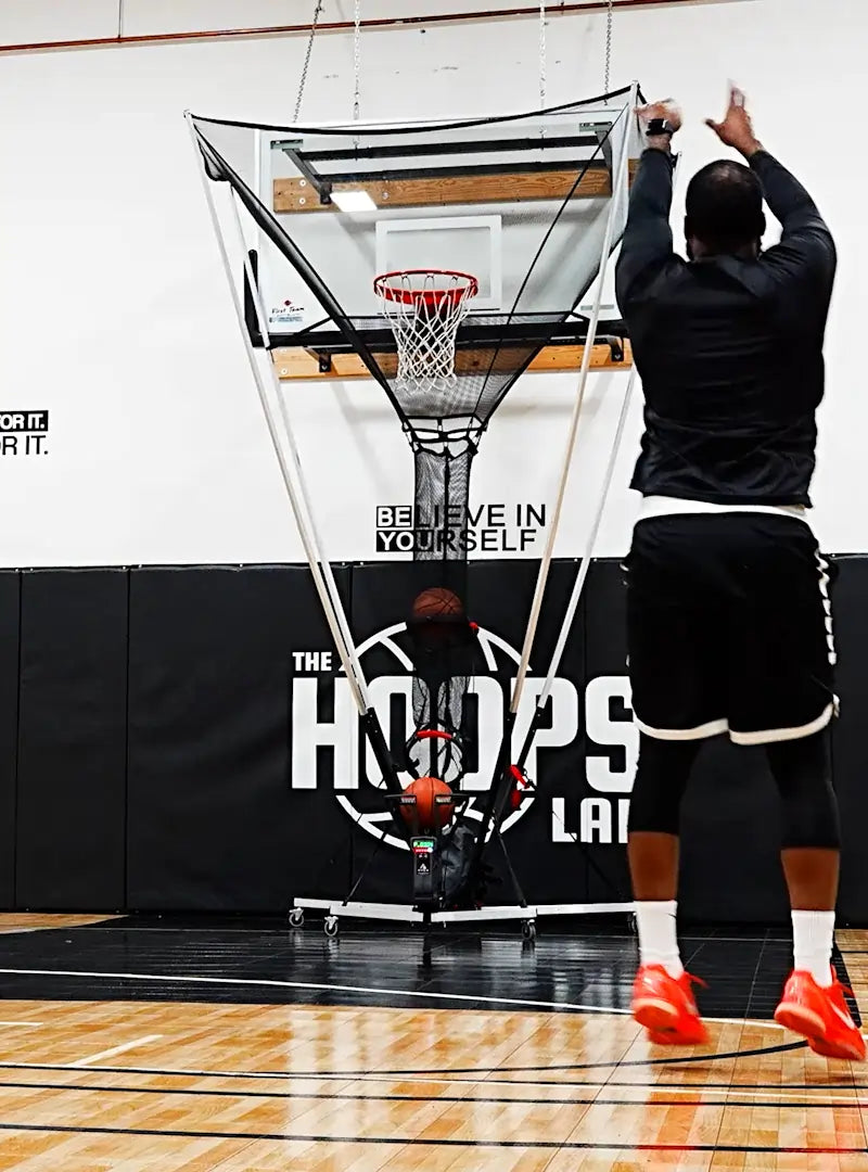 basketball player taking jump shot using the apex basketball shooting machine