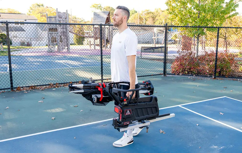man carrying APEX basketball shooting machine 